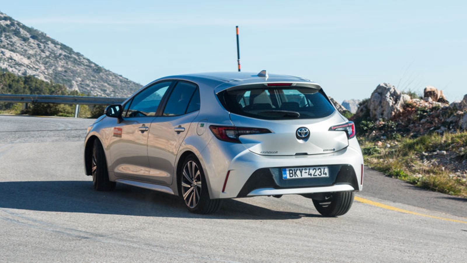 Η Toyota Corolla Hybrid από πίσω σε στροφή, αριστερή γωνία
