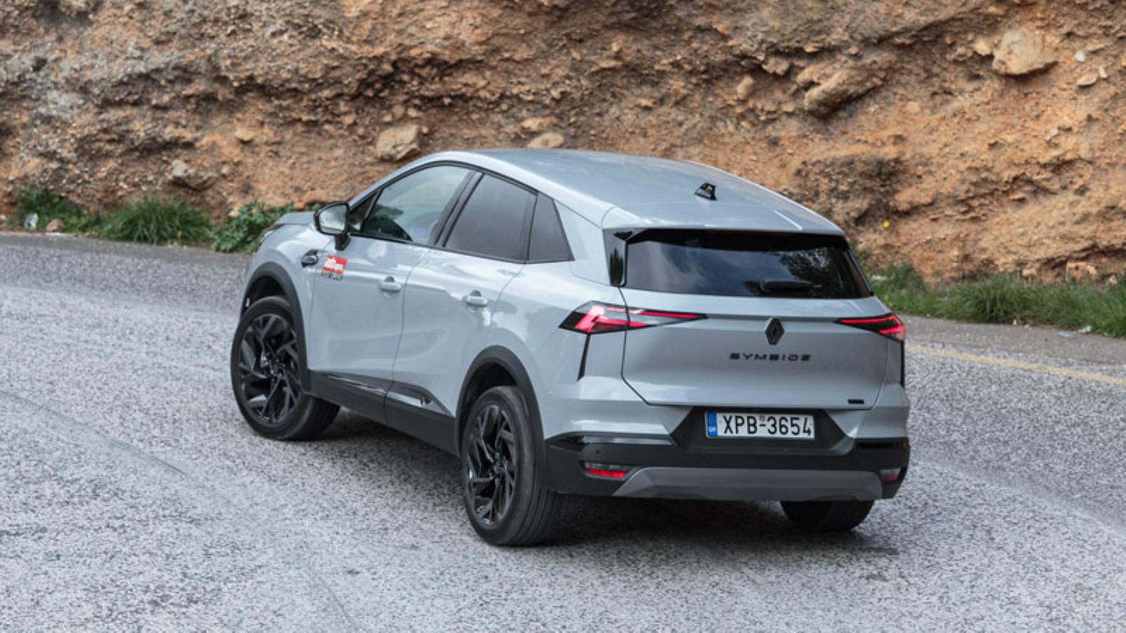 Το Renault Symbioz E-TECH από πίσω σε στροφή, αριστερή πλευρά