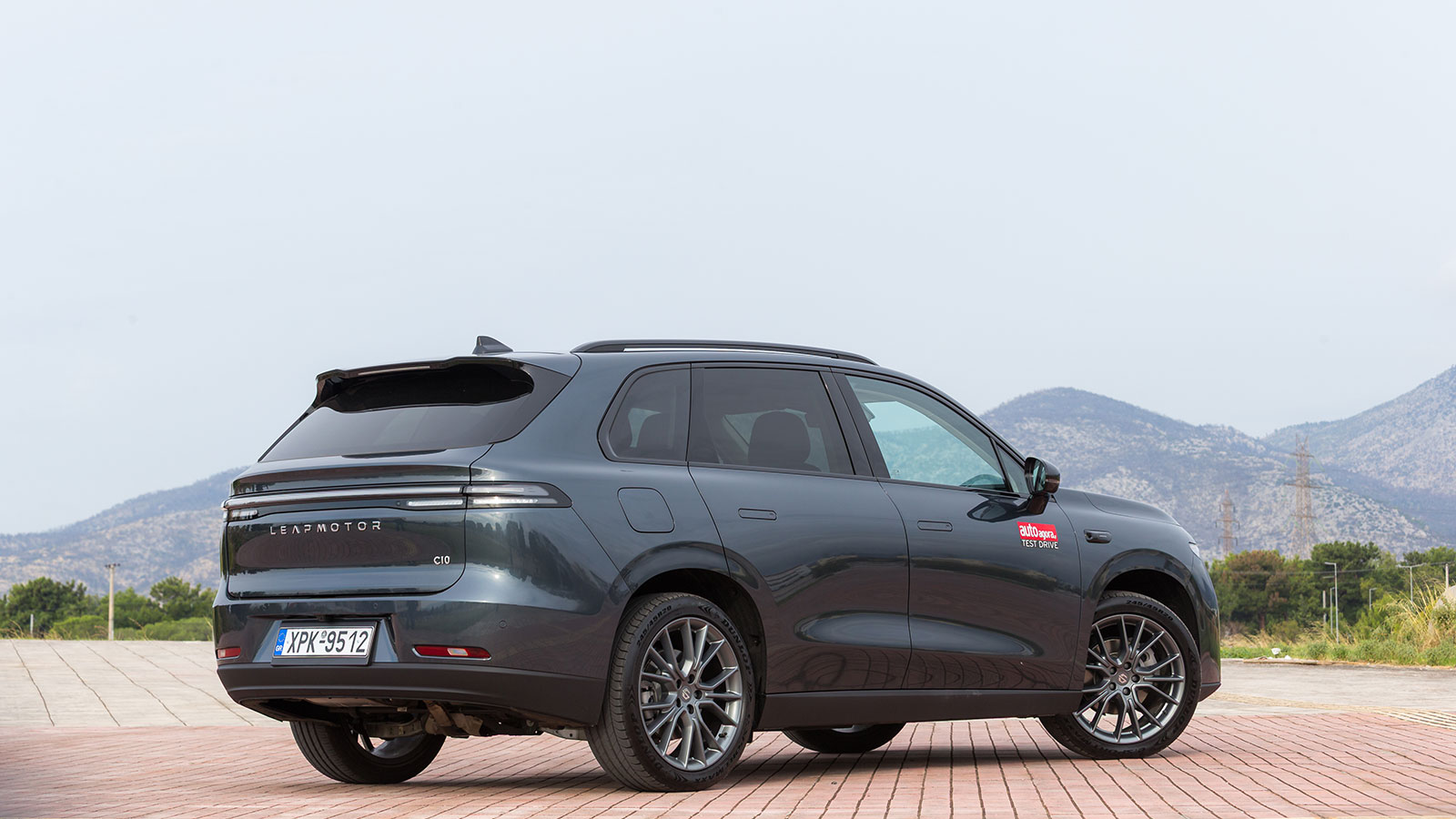 Μοντέρνο μεσαίο SUV που κινείται με ρεύμα όσο ο βενζινοκινητήρας παράγει ενέργεια