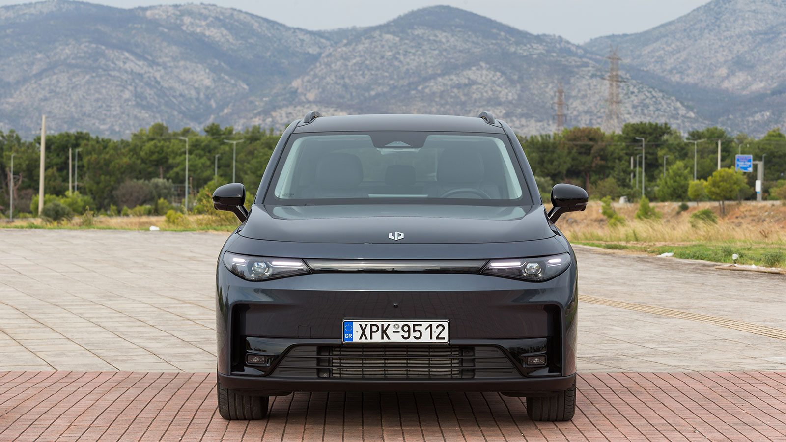 Μοντέρνο μεσαίο SUV που κινείται με ρεύμα όσο ο βενζινοκινητήρας παράγει ενέργεια