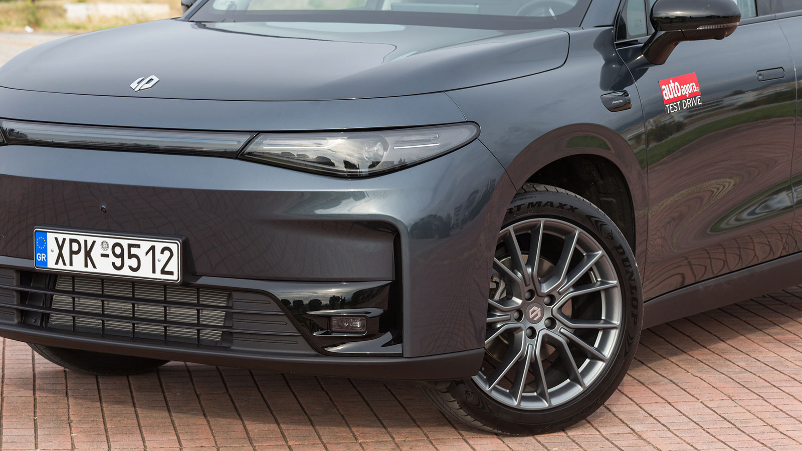 Μοντέρνο μεσαίο SUV που κινείται με ρεύμα όσο ο βενζινοκινητήρας παράγει ενέργεια