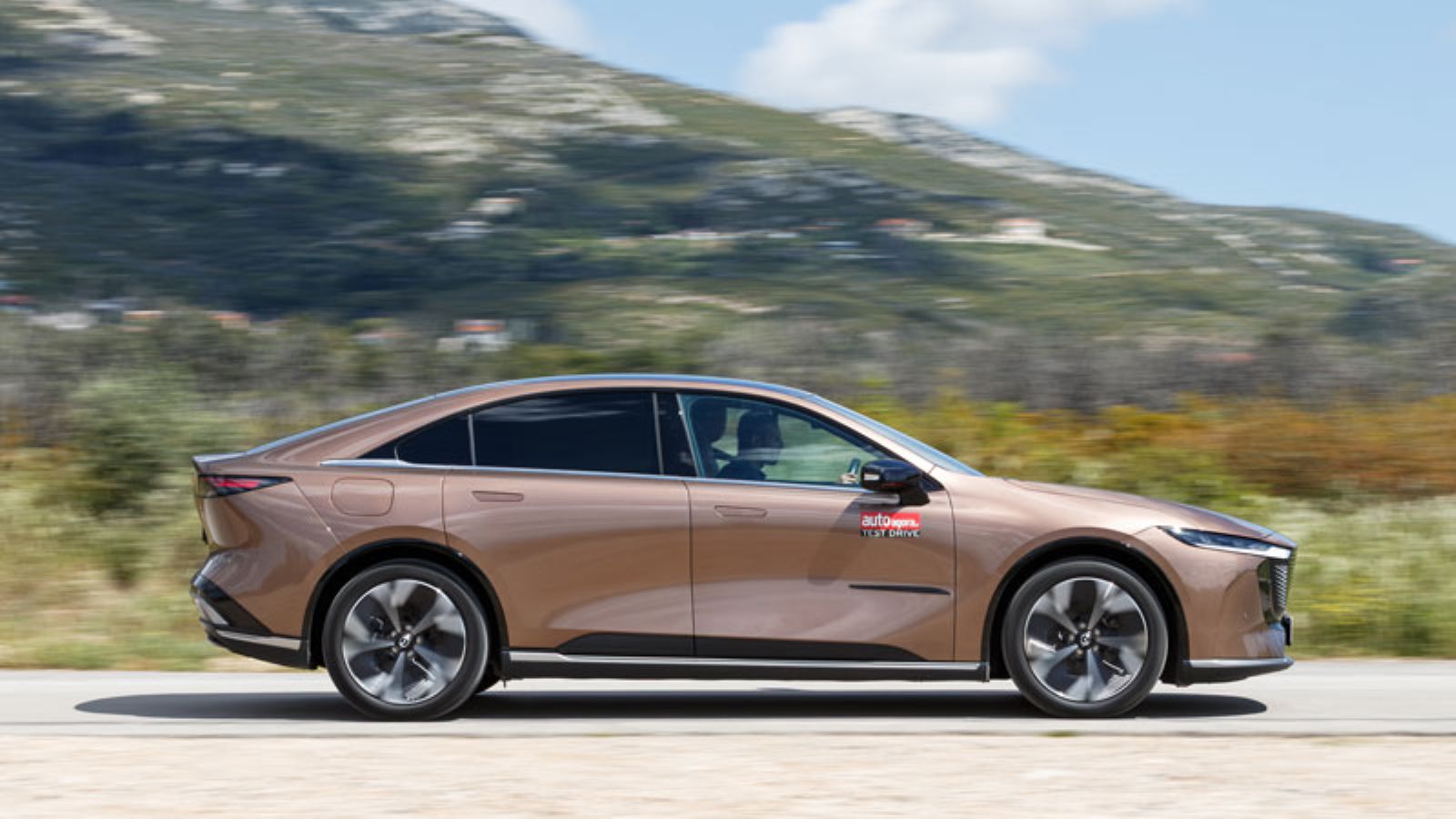 Το Mazda 6e εν κινήσει από το πλάι, δεξιά πλευρά