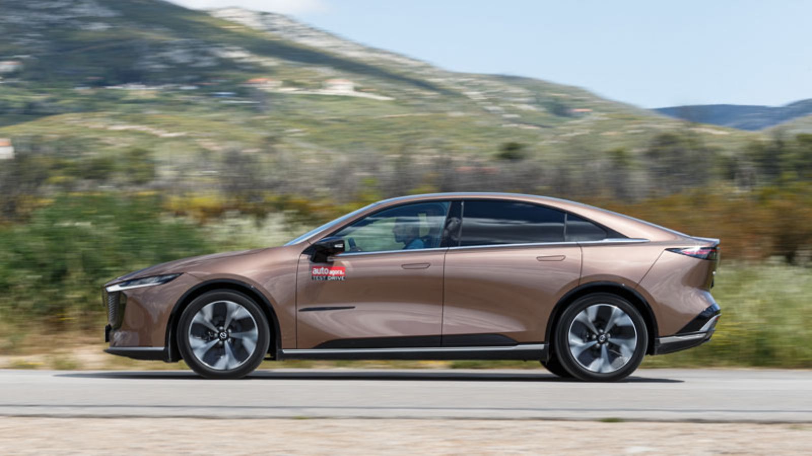 Το Mazda 6e εν κινήσει από το πλάι, αριστερή πλευρά
