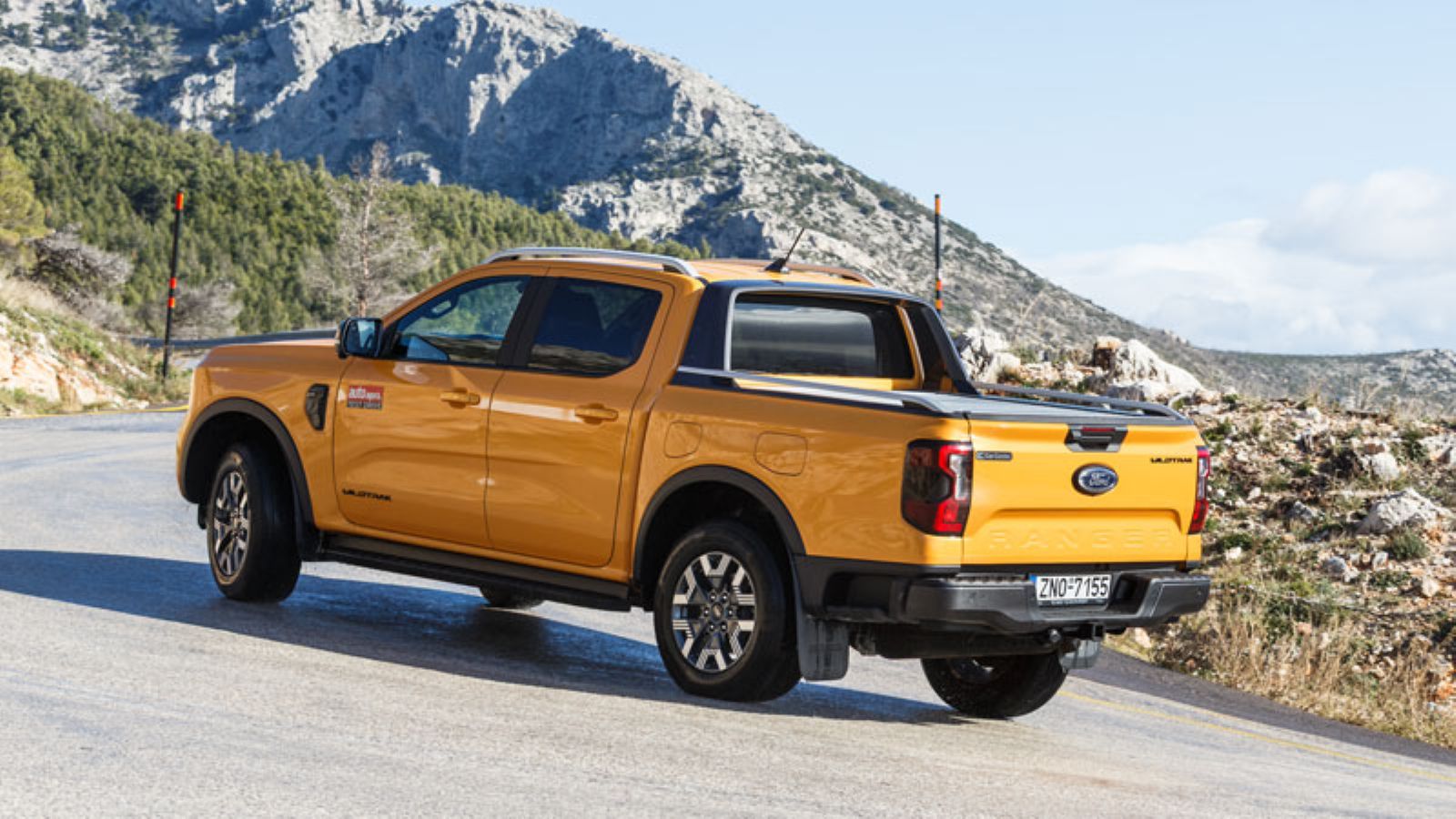 Το Ford Ranger PHEV από πίσω σε στροφή σε άσφαλτο, αριστερή πλευρά