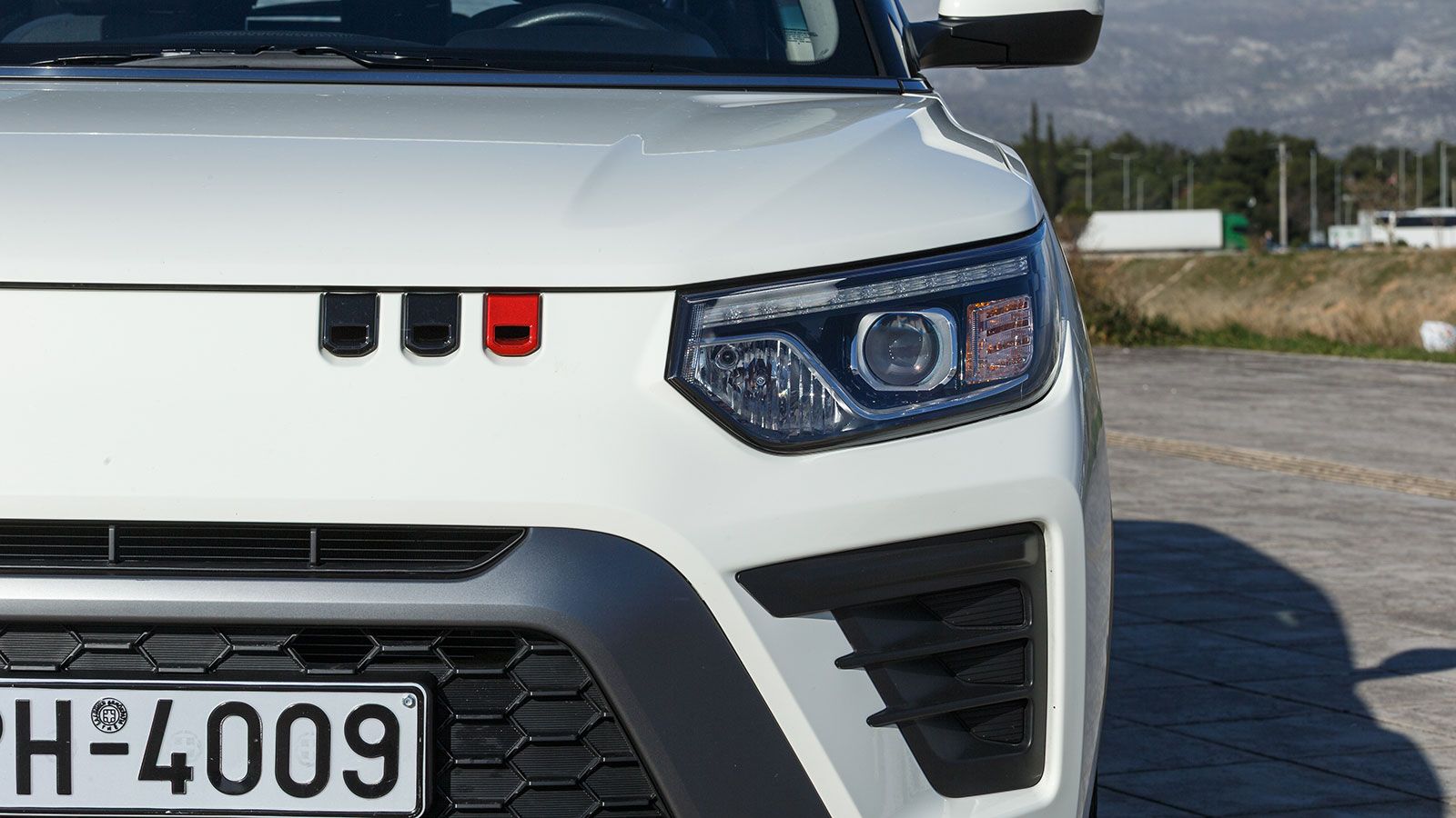 Στα δεξιά του, τρεις διακοσμητικές γραμμές μοιάζουν να «στάζουν» από το καπό.