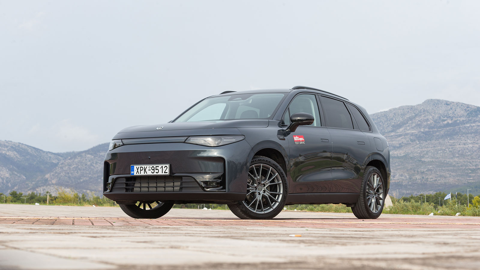 Μοντέρνο μεσαίο SUV που κινείται με ρεύμα όσο ο βενζινοκινητήρας παράγει ενέργεια