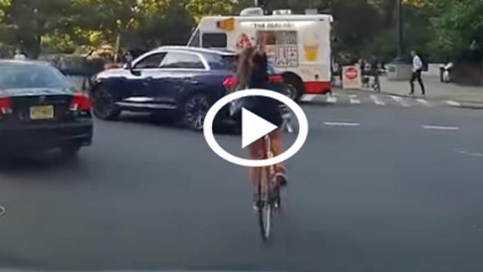 Ποδηλάτισσα χωρίς κράνος κόβει τον δρόμο στη μέση και χειρονομεί 